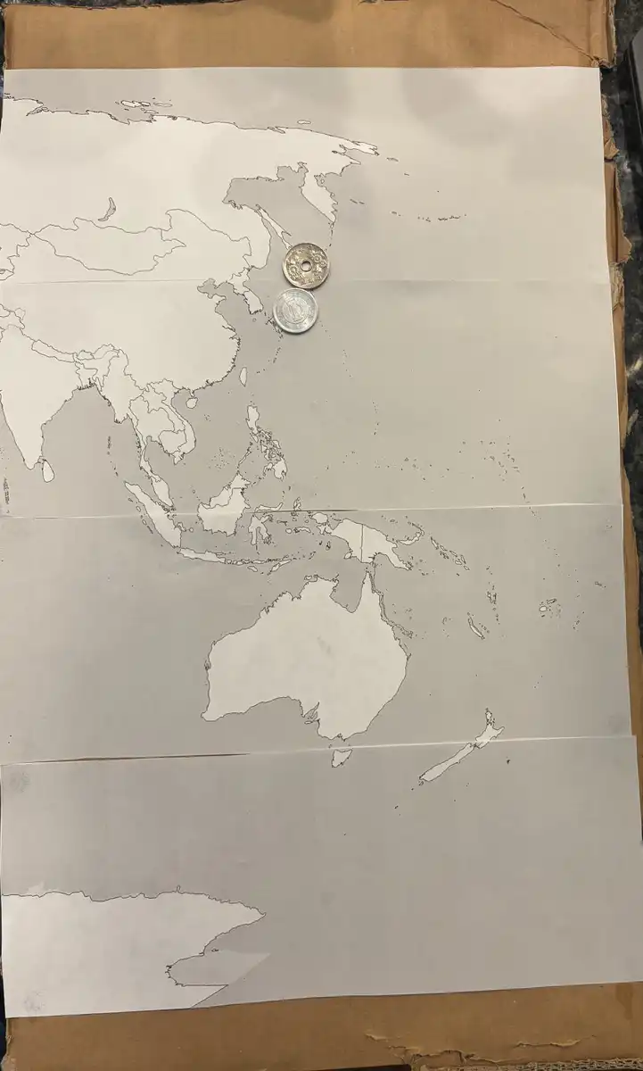 Working-On-A-World-Map-Made-Of-Coins.