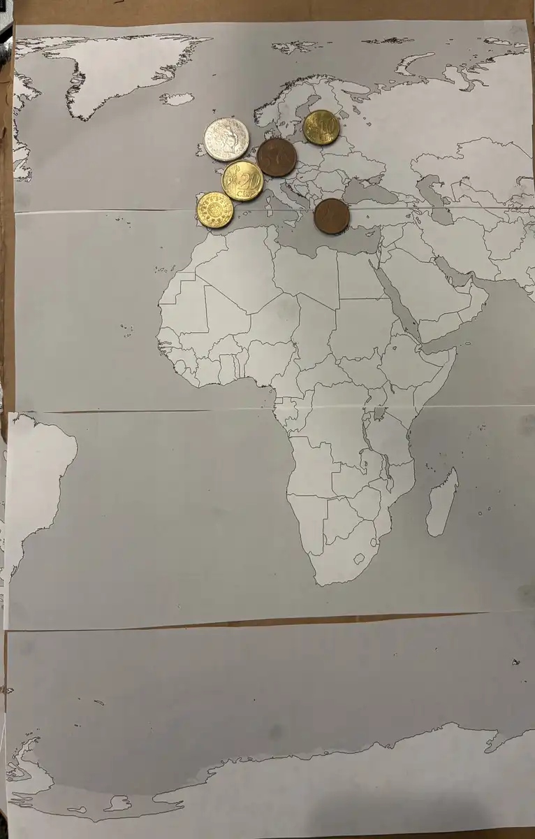 Working-On-A-World-Map-Made-Of-Coins.