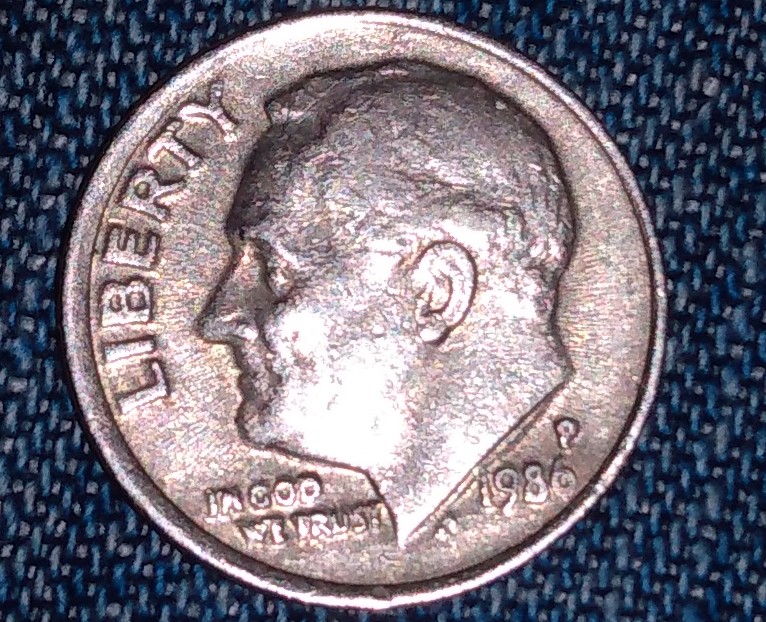Is-This-1986-P-A-Mad-Dime-And-What-Is-The-Extra-Line-Under-His-Neck-On-Front-Side?