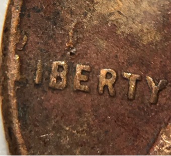 1957-D-Wheat-Penny-With-Another-Coin-Print-Over-Top?