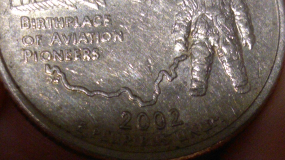 Gouges-In-All-Denominations-Many-Different-Years-In-Shape-Of-The-Letter-