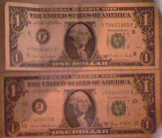 Couple-Of-$1-Bills-Behind-A-Picture-Frame