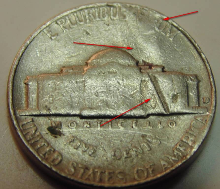 3-Nickels-With-Strange-Enough-Damage-To-Post.