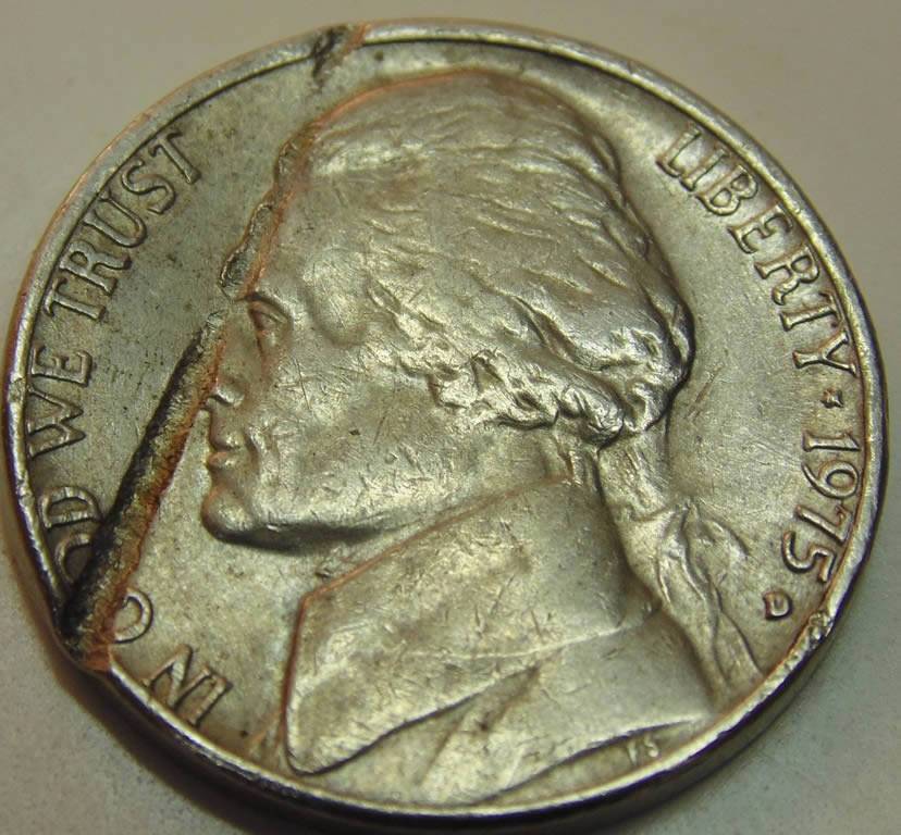 3-Nickels-With-Strange-Enough-Damage-To-Post.