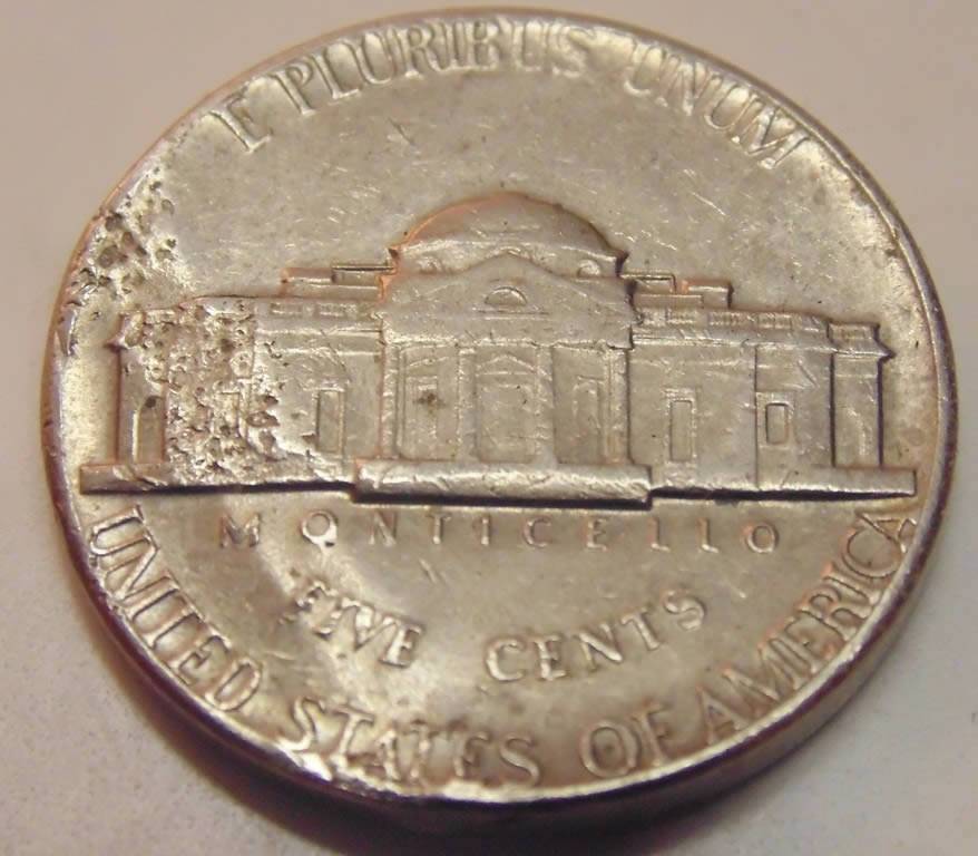 3-Nickels-With-Strange-Enough-Damage-To-Post.