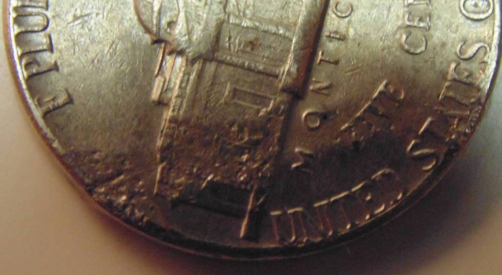 3-Nickels-With-Strange-Enough-Damage-To-Post.