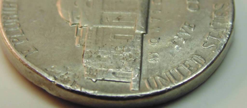 3-Nickels-With-Strange-Enough-Damage-To-Post.
