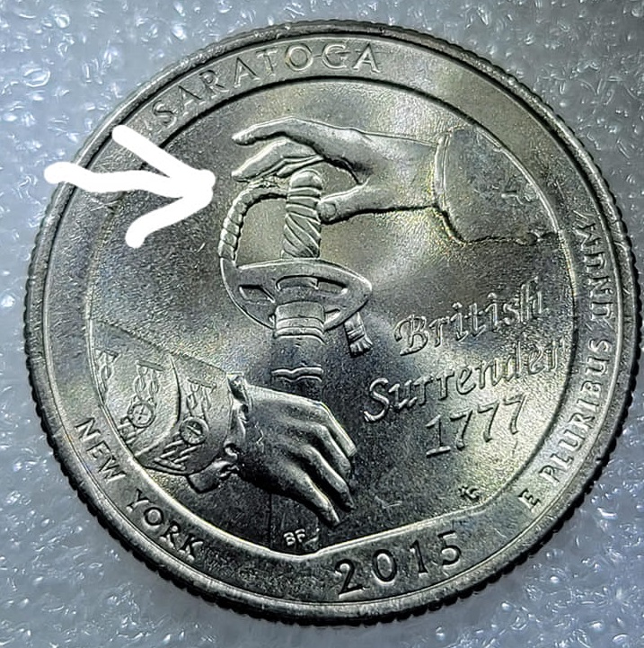2015-Quarter-With-Die-Chip-Between-Finger-&-Sword-Handle