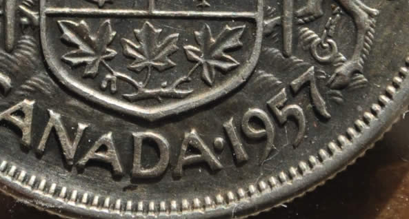 1957-50-Cents-With-Extra-Metal-On-5-In-Date