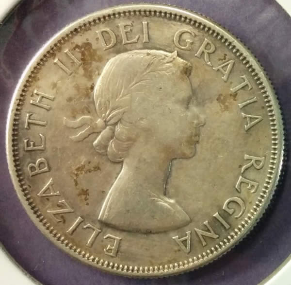 1957-50-Cents-With-Extra-Metal-On-5-In-Date